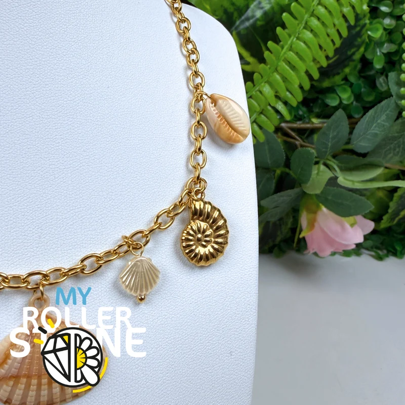 Collar babero con colgantes de acero inoxidable y conchas marinas.