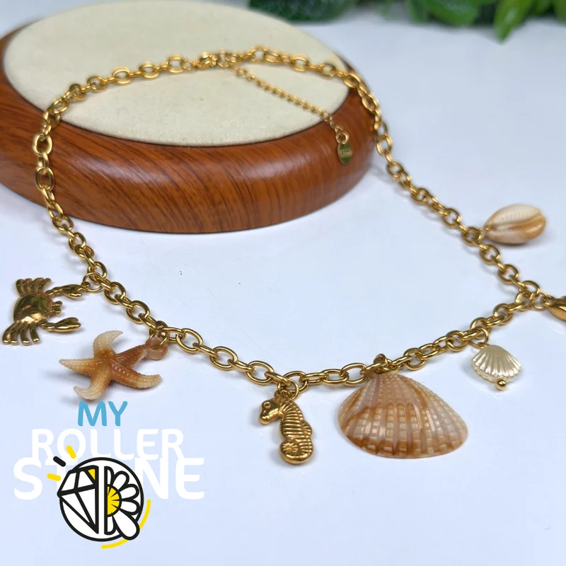 Collar babero con colgantes de acero inoxidable y conchas marinas.